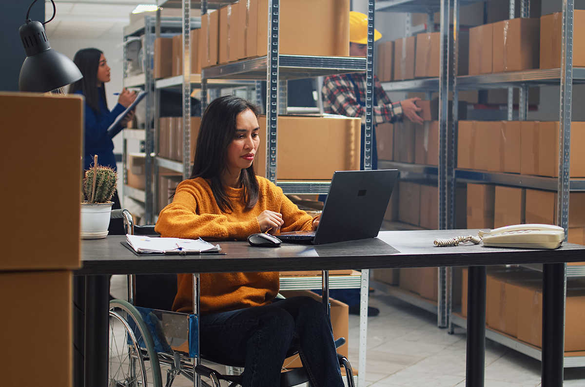 Asian,Woman,With,Disability,Working,In,Warehouse,,Doing,Office,Work