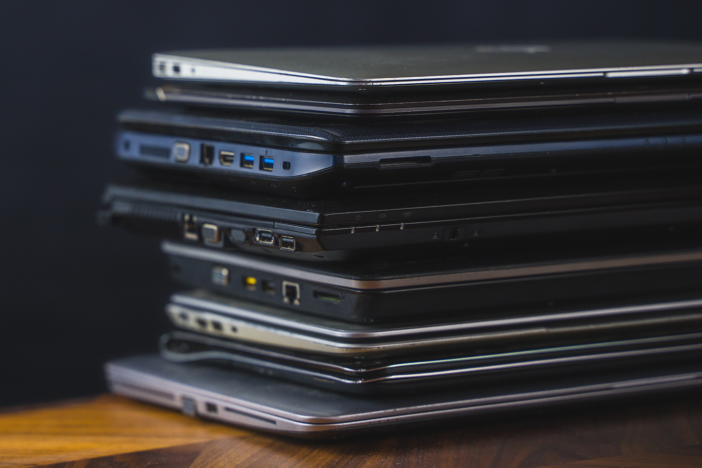 Stack,Of,Old,Laptops,With,Dark,Background